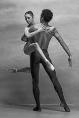 Couple of ballet dancers posing over gray background