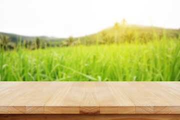 Wooden table with rice field in Thailand.