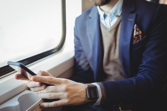Businessman using mobile phone while traveling