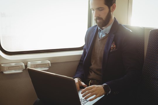 Businessman using laptop while travelling