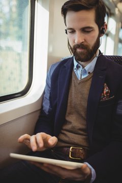 Businessman using digital tablet while travelling