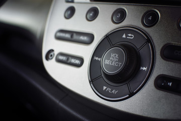 Close up dashboard of a volume control music and radio in car with selective focus.