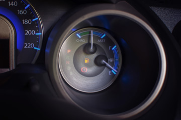 Dashboard of a car fuel gauge and low fuel signal.