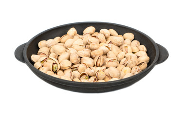 Pistachio nuts in frying pan isolated on white background