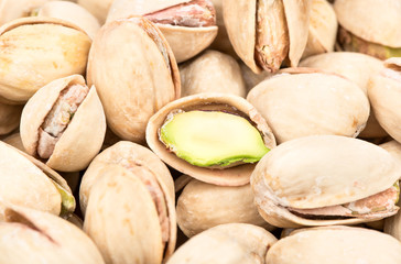 Background of salted pistachio nuts with half close-up