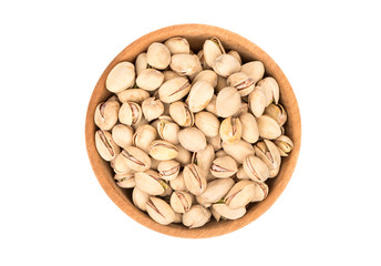 Pistachio nuts in a wooden bowl on a white background, top view