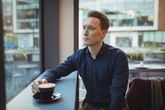 Male executive having coffee at counter