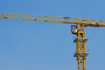yellow construction tower crane with blue sky