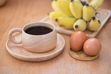 Breakfast set. Soft-boiled egg and banana with hot coffee