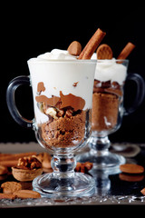 Sweet dessert with chocolate, cocoa, nuts and whipped cream