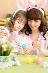 Mother and daughter paint Easter eggs