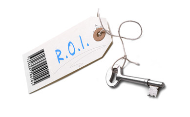 A silver key with a tag attached with a R.O.I concept written on it.
