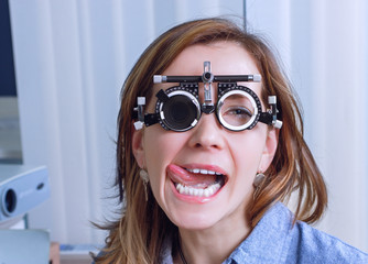 Girl woman in messbrille glasses in ophthalmology clinic. Ophthalmic glasses for diopter detection.