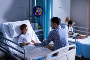 Father consoling his son during visit in ward