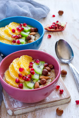 Healthy breakfast oatmeal with different fruits, pomegranate and nuts