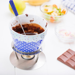 Chocolate fondue cooked on a candle flame.