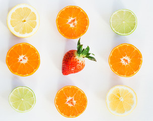 Top view of eight slices of citrus fuits and one strawberry, on the white background
