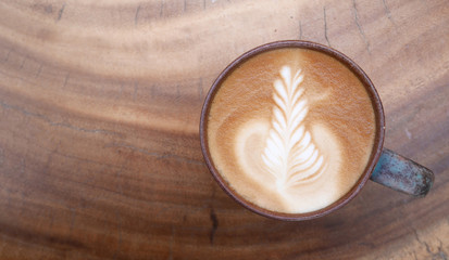 Top view of hot coffee latte art on wooden table background
