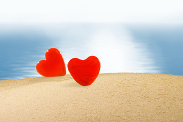  two hearts in the sand against the sea