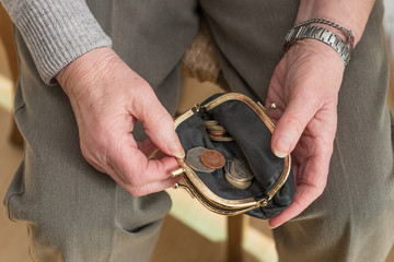Hands of a pensioner checking loose change in purse