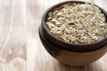 Uncooked oats in the wooden bowl, selective focus