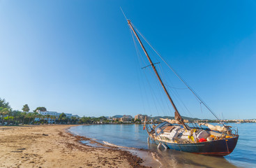 Abandoned & stranded, rusty old sail boat on the beach in Sant Antoni De Portmany. Warm sunny day...