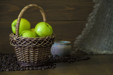 Apples are green in the basket on the background of sacking