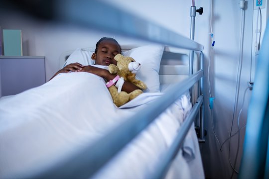 Patient sleeping with teddy bear on the bed