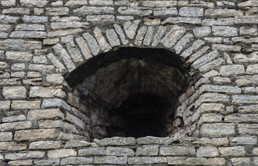 Embrasure in old gray stone wall
