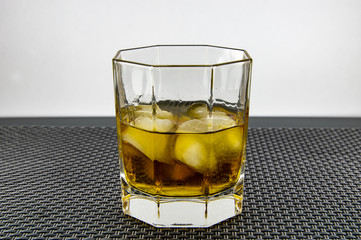 A glass of whiskey and ice.