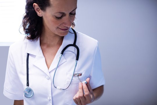 Female Doctor Checking Time On Pocket Watch