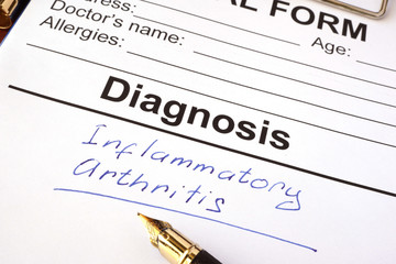 Medical form with diagnosis inflammatory arthritis on a table.