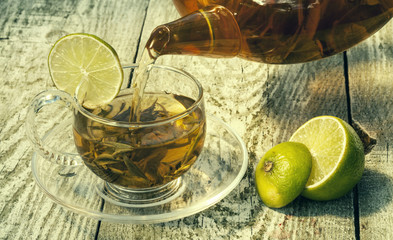 Green tea with lemon on a wooden table. Tea with lemon. Green tea. Tea in a glass teapot.