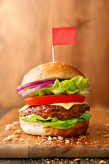 Tasty hamburger on a wooden board