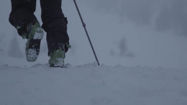 Hiking in winter snow at dawn with ski boots (slow motion)
