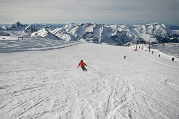 Fotobehang Girl skier making large turns in snowy mountains © philup
