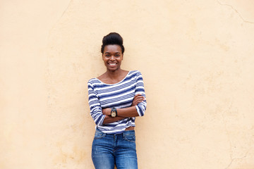 happy young black woman smiling with arms crossed