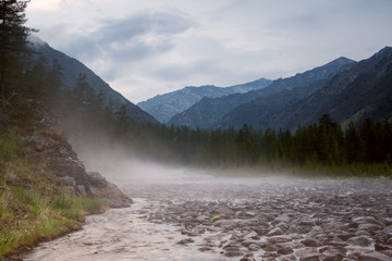 Fog over a rocky mountain stream. The River Indigirka. The Republic Of Sakha. Russia.
