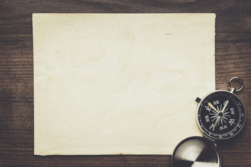 compass and old paper on the brown wooden table background