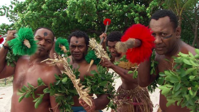 Four Fijian men with decorated spears taking part in traditional ceremony