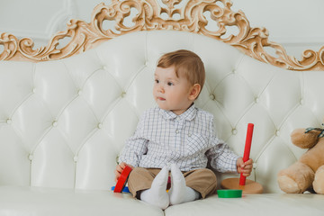 Naklejka premium Baby playing with a toy on the couch.