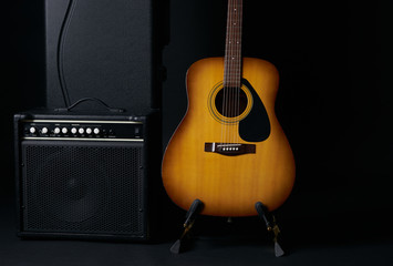 Acoustic guitar black hard case and classic amplifier on a dark background