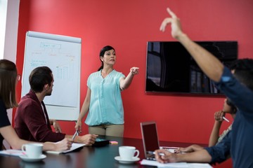 Business executives discussing over flip chart during meeting