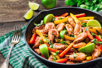Fried shrimps with bell peppers, cilantro and lime