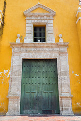 Large green door on the Church of the Holy Trinity in the Getsemani neighborhood of Cartagena, Colombia.