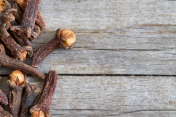 Cloves on grey rustic wooden background. Top view with copy space
