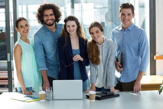 Portrait of smiling business team standing together in meeting