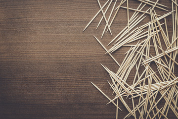 many wooden toothpicks on the brown table background