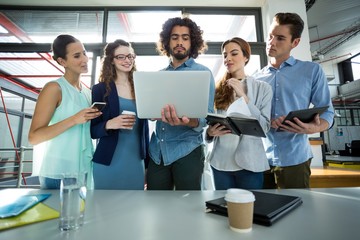 Business team discussing over laptop in meeting