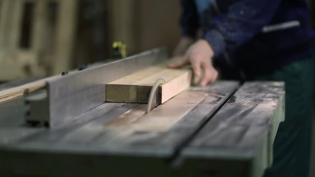 Carpenter working on electric saw cutting boards
